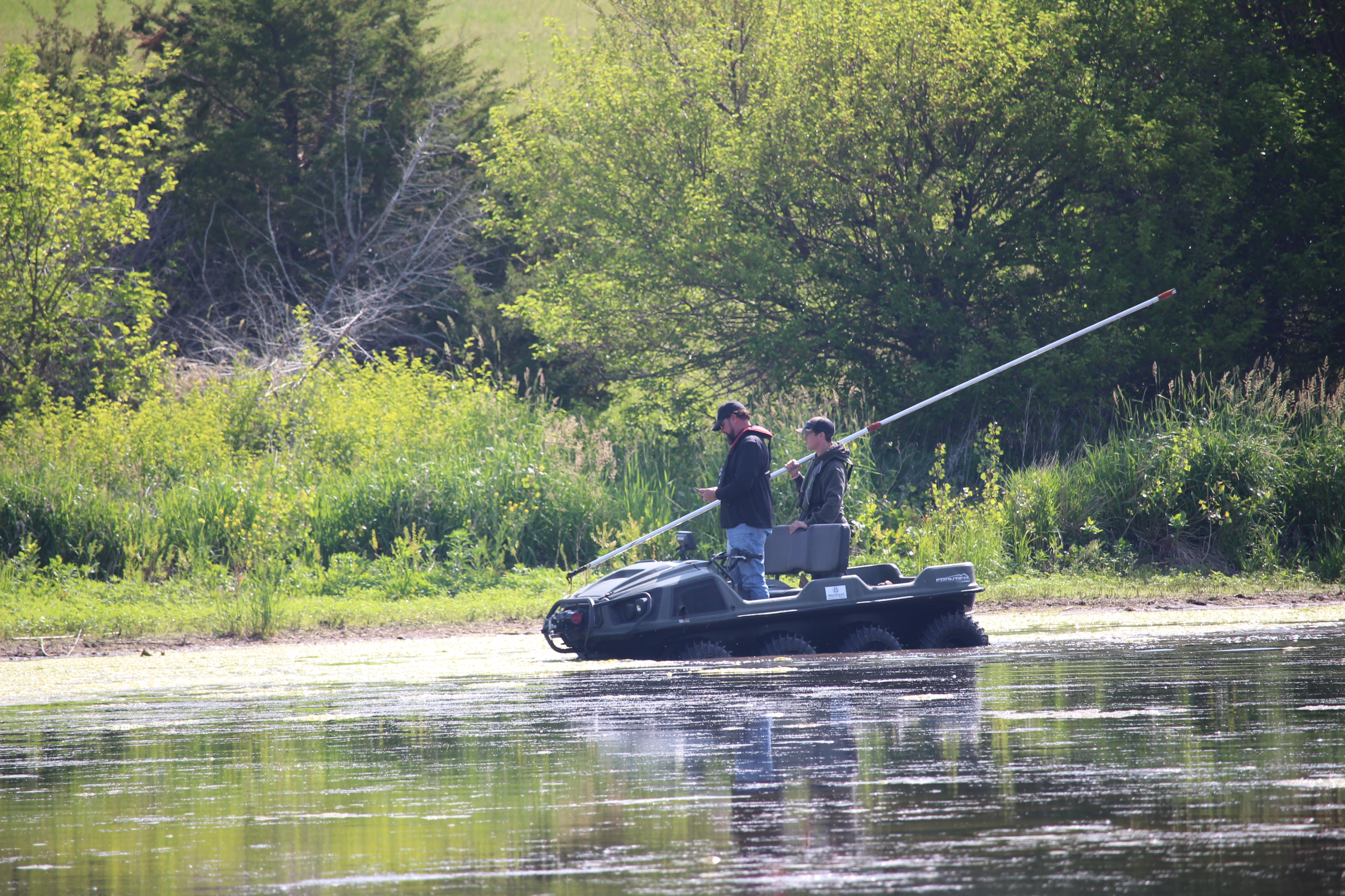 Two males take measurements in the lake at Pioneer Trails Recreation Area for a bathymetric survey.