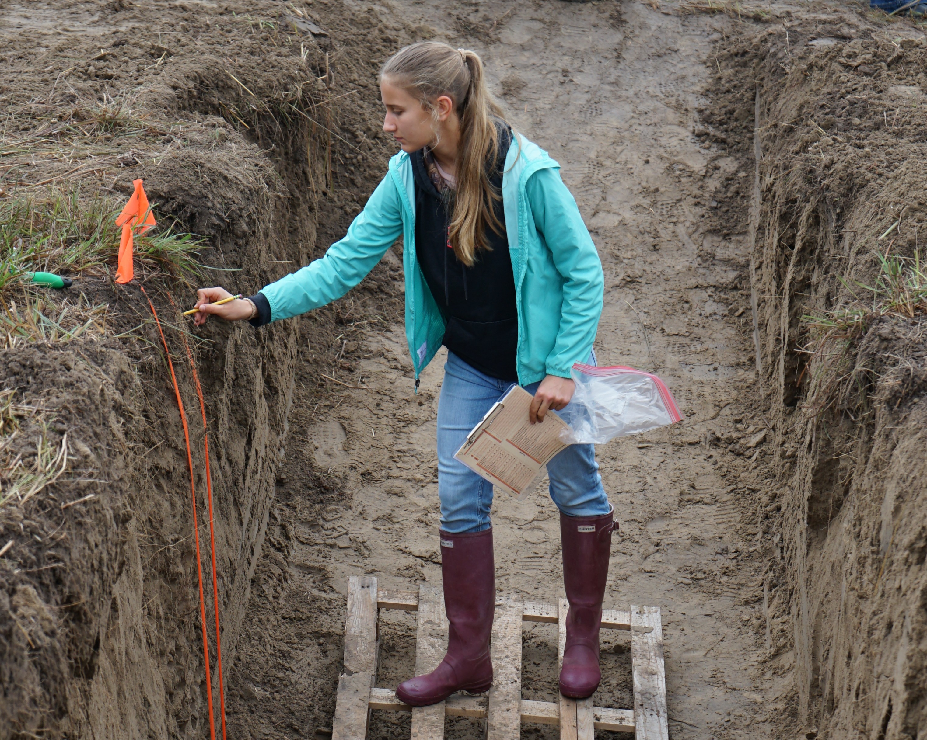A student uses the "pencil test" to help assess soil texture during the 2026 South Central Land Judging Contest..