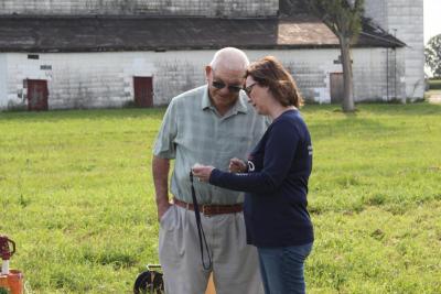 Board member Merlin Volkmer and NRD staff member Nancy Brisk look at a multimeter tool used in water sampling at monitoring wells near Fairmont. 