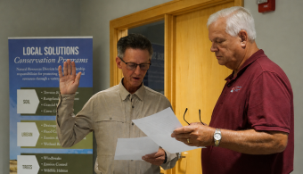 Gale Holmes takes the oath of office with General Manager David Eigenberg as a witness.