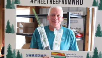 A visitor to the NARD booth at Husker Harvest Day poses with his free tree.